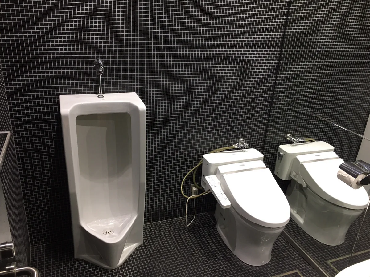 ホール専用のお手洗い。黒いタイルの内装と温水洗浄便座